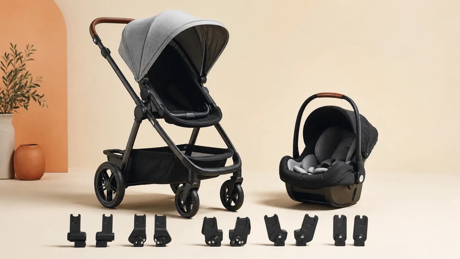 Unbranded stroller, infant car seat and several adapter components arranged in a clean studio