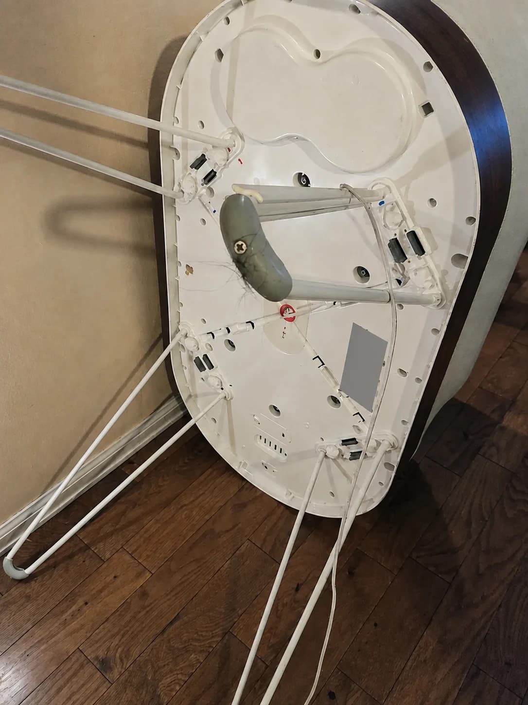 Our SNOO tilted for a view of the underside, metal legs and a gray foot pad