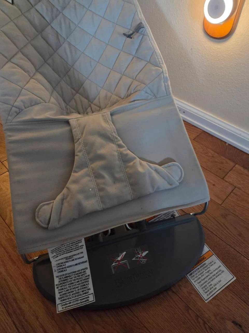 Close-up of the quilted BabyBjörn bouncer seat and unfastened fabric restraint panel