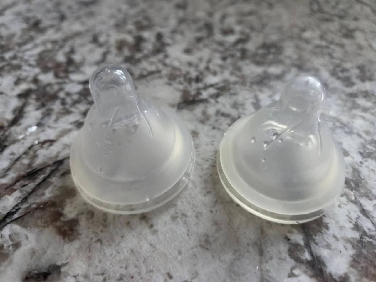 Two translucent bottle nipples from our home photographed side by side on the kitchen counter
