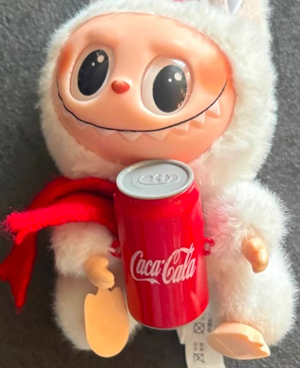 Fake white Coca-Cola-themed Lafufu with a red scarf and toy soda can