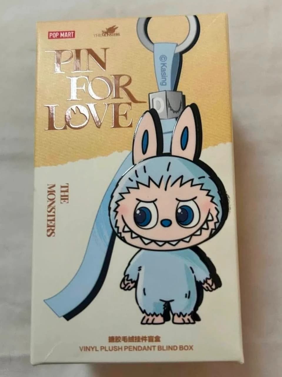 Pin for Love vinyl plush pendant box with blue Labubu artwork and a D letter block